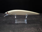 A cream-colored hard fishing lure with a red eye and clear plastic diving lip, displayed on a clear acrylic stand against a dark background.