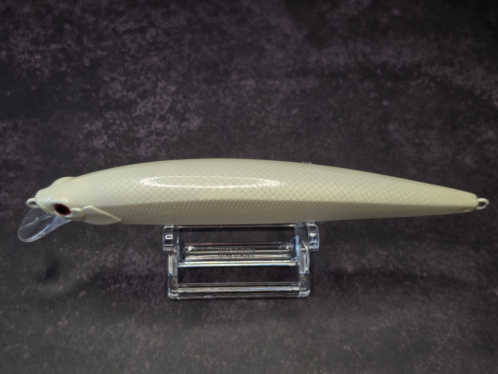 A cream-colored hard fishing lure with a textured scale pattern, resting on a clear acrylic stand against a dark textured background.
