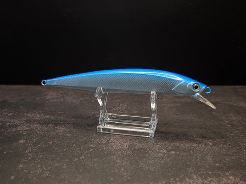 A blue and silver hard bait fishing lure with a clear plastic diving lip, displayed on a transparent acrylic stand against a dark background.